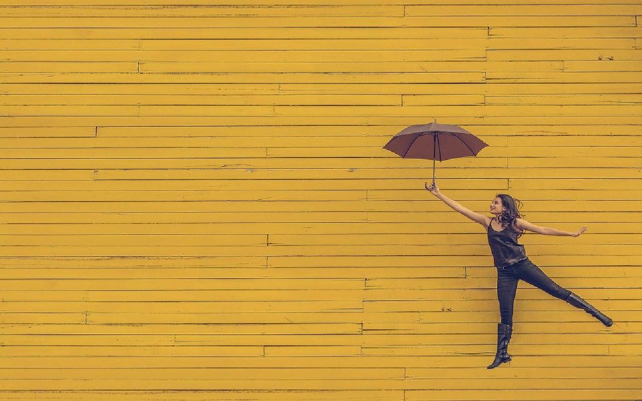 Frau fliegt mit Regenschirm